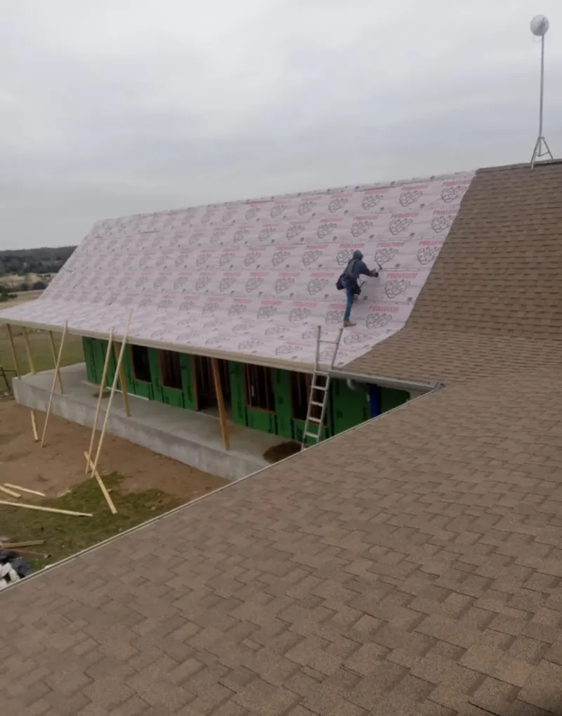 Worker preparing underlayment for a metal roof installation in Lancaster
